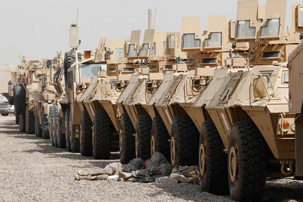 Американские солдаты отдыхают в тени бронетехники в лагере Свободы в Багдаде, 30 сентября 2011 года.