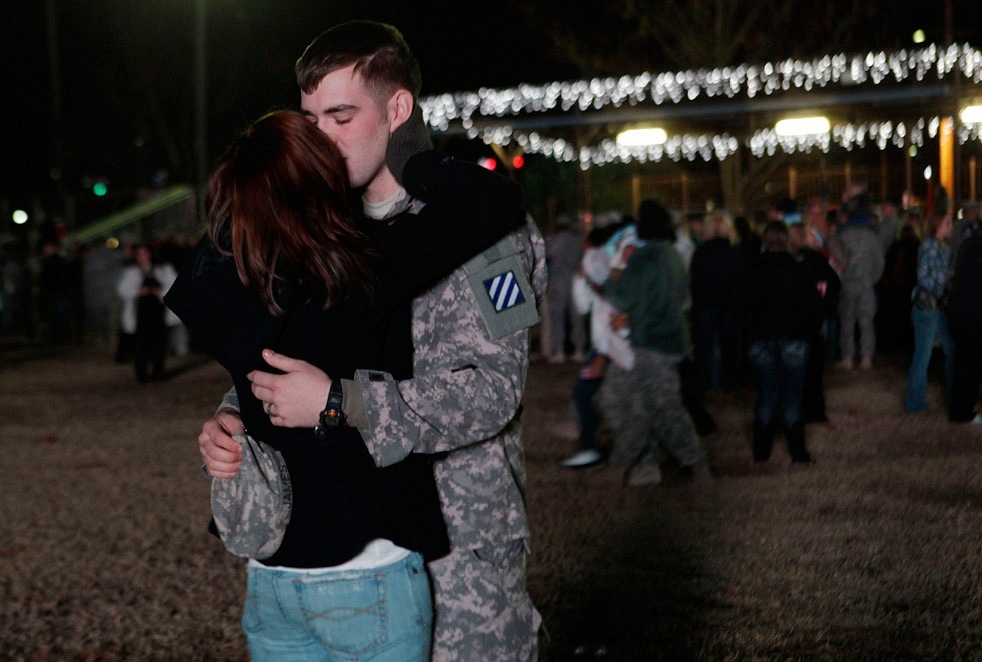 Американский солдат целует свою жену после года разлуки.
