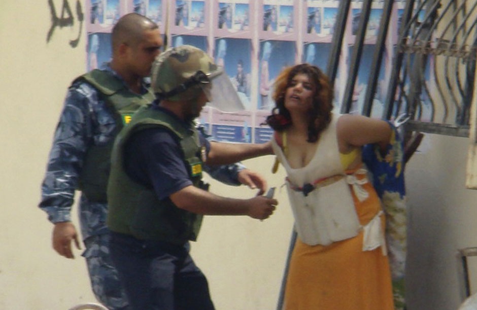 Иракские полицеские снимают с женщины пояс со взрывчаткой, 24 августа 2008 года.