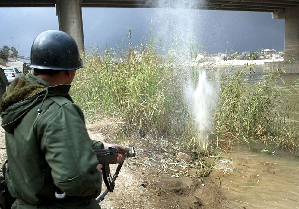 Иракский солдат стреляет на берегу реки Тигр в Багдаде, 23 марта 2003