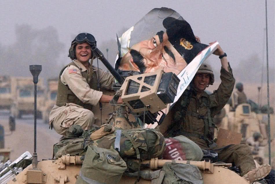 Солдаты 3-й пехотной дивизии с портретом Саддама Хусейна на пути через Багдад 9 апреля 2003.