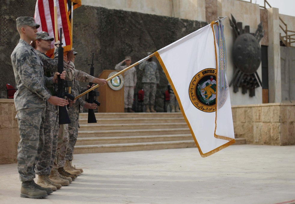 Флаг, используемый американскими силами в Ираке, опускают во время торжественной церемонии в Багдаде, Ирак, 15декабря, 2011 года.
