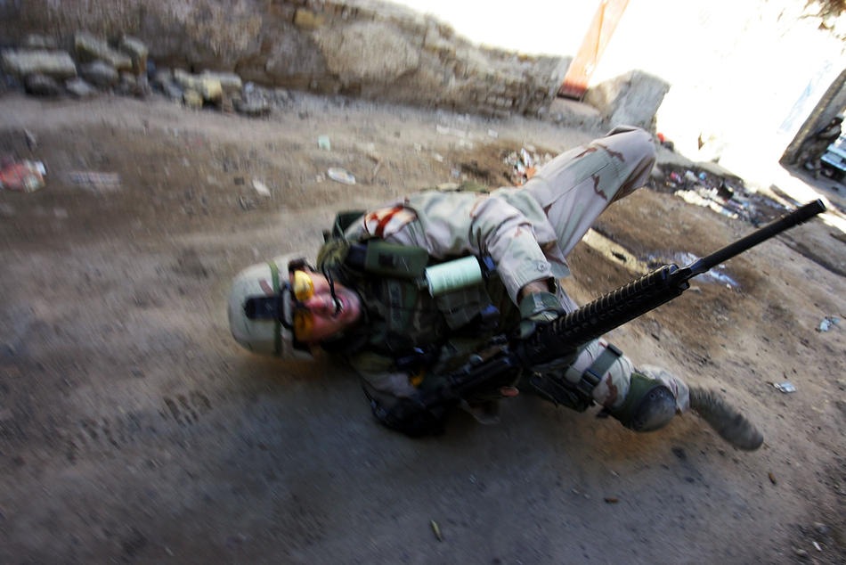 падает на землю, после ранения во время перестрелки 16 февраля 2005 года в Багдаде.