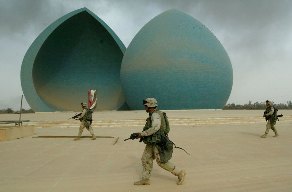 проходят мимо Памятника мученикам во время операции по захвату центральной части Багдада, 9 апреля 2003 года.